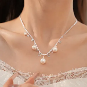 Detailed close-up of an elegant pearl and zircon fringe necklace on model's neck
