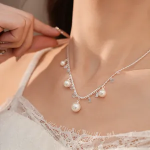 Close-up of elegant lace-style silver necklace with white pearls and blue zircons