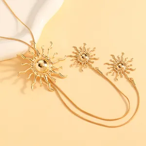 Detailaufnahme eines goldenen sonnenförmigen Schmucksets mit Kette und Ohrringen