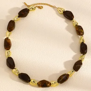 Detailed macro shot of a chunky beaded necklace with brown resin and gold irregular beads.