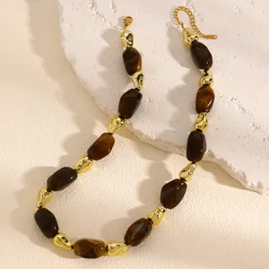 Detailed view of irregular brown marbled resin and gold beads on a textured stone surface