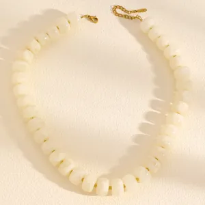 Close-up of white resin barrel-bead necklace with adjustable gold-tone extender chain