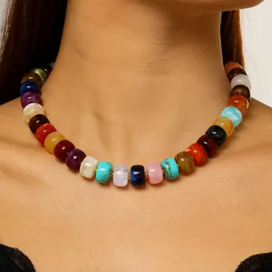 Close-up of a colorful dopamine style beaded rainbow necklace on a woman's neck.
