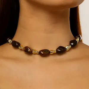 Detailed close-up showing a beaded choker necklace with brown resin and gold metallic accents