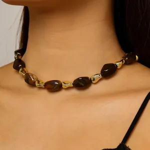 Close-up of a stylish irregular tortoise shell resin and gold bead necklace worn on neck