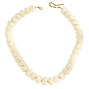 Close-up detail of chunky cream marbled bead necklace with a gold clasp hardware