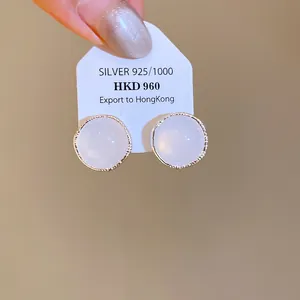 Detailed macro view showing the textured metal rim of elegant round white agate stud earrings.
