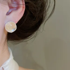 Close-up view of retro silver stud earring featuring an iridescent faux agate stone