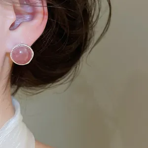 Elegant vintage pink agate stud earring with textured silver rim worn on a model's ear