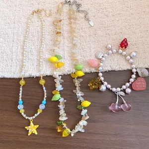 Vista dettagliata del set di gioielli alla frutta con bracciale di perle e collana con stella