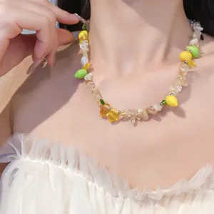 Primo piano di una collana di perle in resina con ciondoli a forma di limone gialli e verdi