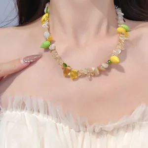 Dettaglio di una collana di perle di frutta in resina indossata da modella