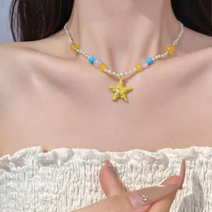 Primo piano di una collana di perle di resina colorata con ciondolo a stella marina gialla.