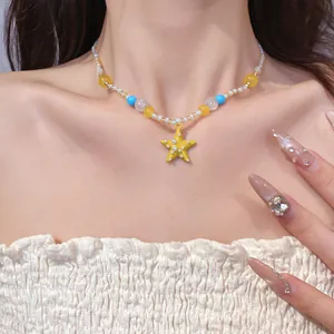 Primo piano di una collana di perline colorate con pendente a stella gialla sul collo