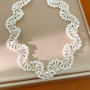 Detailed shot of a vintage white glass beaded scalloped necklace with clear crystals.