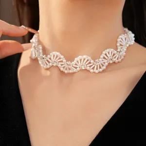 Detailed close-up of a vintage white glass beaded choker with sparkling crystal accents