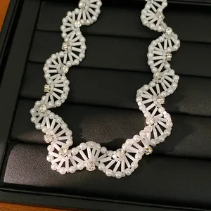 Detailed macro view of vintage white glass beaded necklace with sparkling rhinestone accents