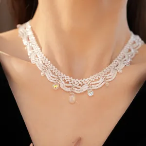 Close-up detail of a white glass beaded lace necklace featuring iridescent drop charms