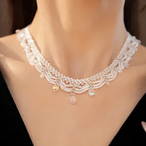 Detailed shot of a vintage white beaded lace necklace with iridescent crystal pendants.