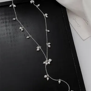 Detailed macro view of a silver Y-shaped necklace adorned with small white pearls