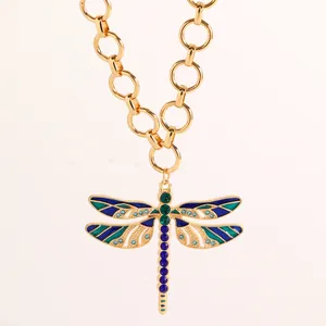 Dettaglio del ciondolo a forma di libellula vintage con strass blu su una catena d'oro spessa