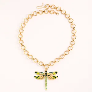 Dettaglio della collana con ciondolo a libellula dorata con strass verdi e smalto.