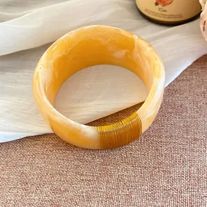 Vue détaillée d'un bracelet en résine marbrée avec décoration en fil d'or