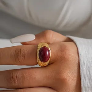 Dettaglio di un anello vintage placcato oro con trama stropicciata e pietra rossa