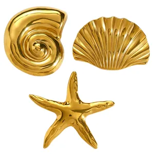 Close-up of gold vintage marine brooch set featuring starfish, scallop, and conch