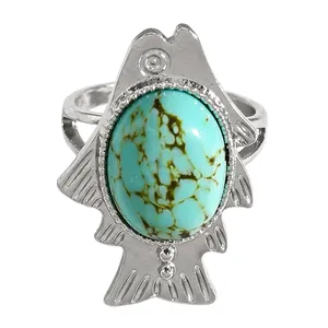 Close-up of vintage silver-tone fish ring featuring a large oval faux turquoise stone