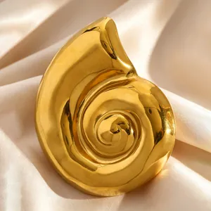 Detailed macro view of vintage golden conch shell brooch with luxury metallic mirror finish