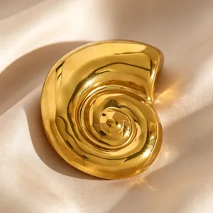 Detail shot of a vintage golden nautilus shell brooch on elegant champagne silk