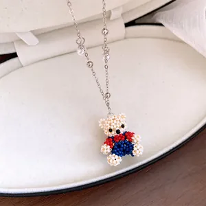 Detailed macro shot of a cute handmade beaded bear pendant necklace with pearl chain