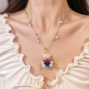 Close-up of sweet beaded bear necklace with delicate pearl accents on silver chain