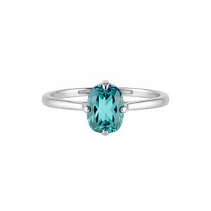 Une bague élégante en argent avec un zircon bleu ovale sur un fond blanc pur