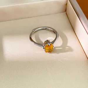 Gros plan d'une élégante bague en argent ornée d'un zircon jaune ovale facetté
