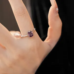 Vue rapprochée d'une élégante bague en zircon violet ovale au doigt