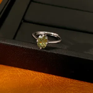 Gros plan d'une bague élégante avec zircon vert et anneau réglable argenté