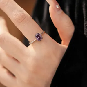 Gros plan d'une bague en argent avec un élégant zircon violet de forme ovale.