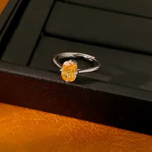 Gros plan d'une bague réglable en argent ornée d'un oxyde de zirconium jaune éclatant