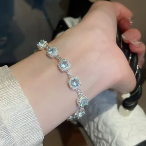Dettaglio di un lussuoso bracciale in zircone con pietre azzurre sul polso