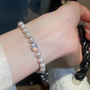 Vista dettagliata di un elegante bracciale di perle bianche con zircone centrale lucido