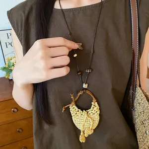 Detailaufnahme der gewebten Strohhut-Halskette im Boho-Stil mit Holzperlen an Model