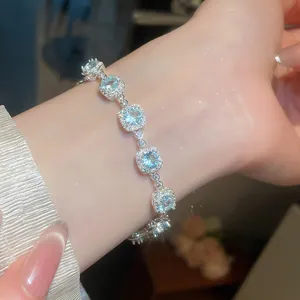 Primo piano di un bracciale scintillante con zirconi blu al polso di una donna elegante