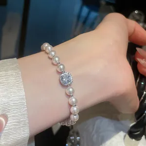 Squisito primo piano di un braccialetto di perle con un ciondolo quadrato in zircone lucido