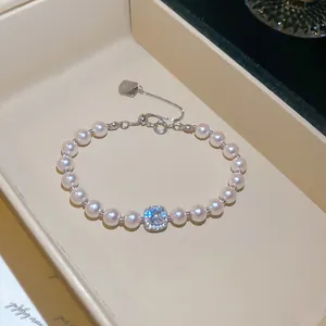 Primo piano di un elegante bracciale di perle con un ciondolo quadrato di zircone scintillante.