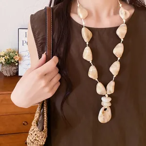 Close-up of irregular cream acrylic stone necklace for an elegant resort look
