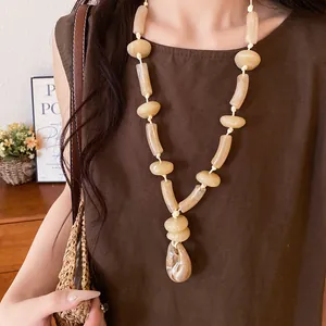 Close-up detail of cream marble texture acrylic bead necklace on a model's neck