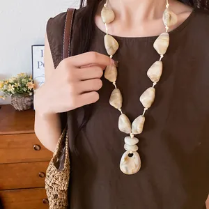 Detailed view of marbled cream acrylic stone beads on a bohemian vacation necklace