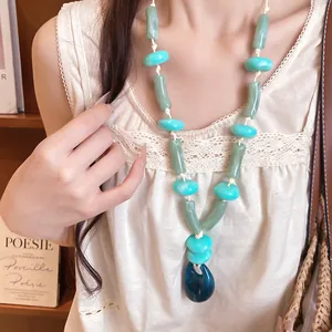 Close-up detail of stylish acrylic beaded necklace in coastal vacation style on model